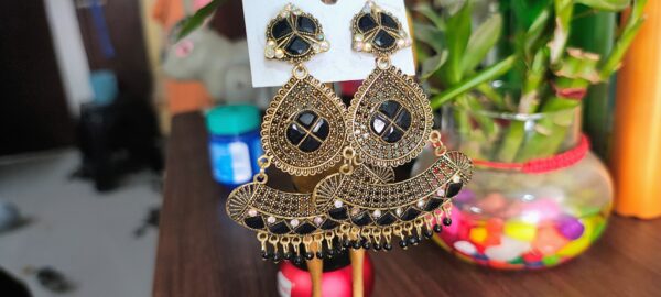 Black drop earrings with a floral design, adorned with sparkling rhinestones and golden accents