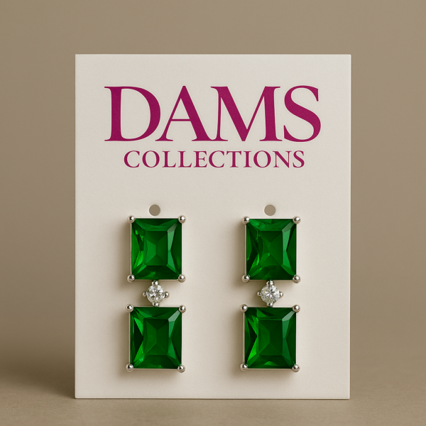 Two pairs of square-cut green stud earrings, each featuring a large green stone and a smaller clear stone, displayed on a white Dams Collections earring card.