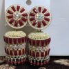 Red jhumka earrings with a floral design, adorned with sparkling rhinestones and gold accents