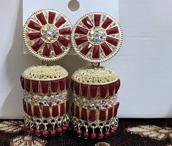 Red jhumka earrings with a floral design, adorned with sparkling rhinestones and gold accents