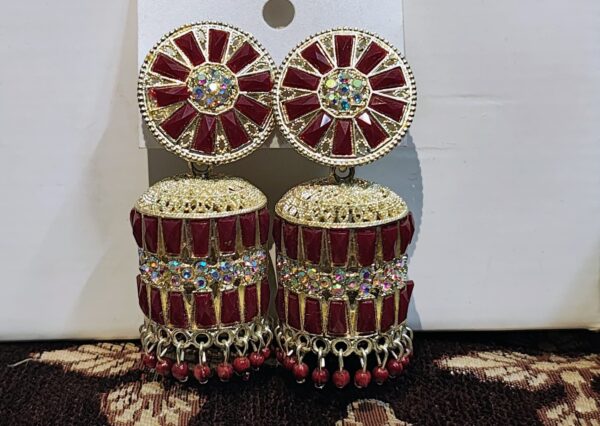 Red jhumka earrings with a floral design, adorned with sparkling rhinestones and gold accents