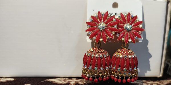 Red jhumka earrings with floral design and sparkling rhinestones