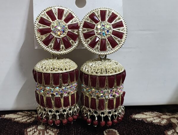 Red jhumka earrings with a floral design, adorned with sparkling rhinestones and gold accents