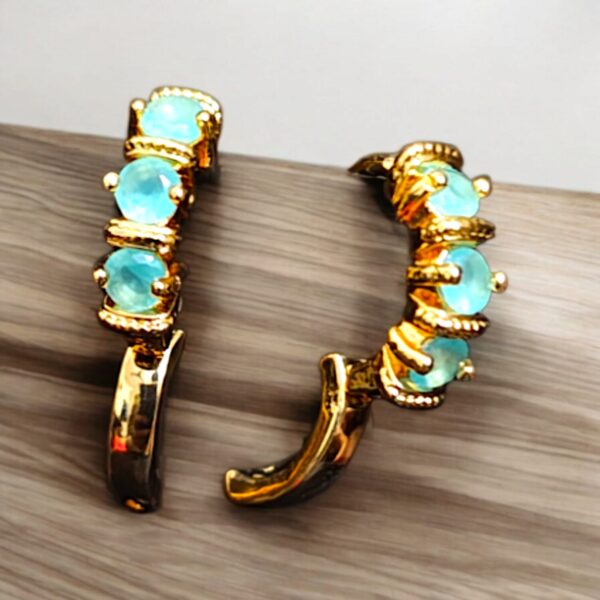 Sea green stone hoop earrings with a golden finish, set on a wooden background, ideal for stylish and affordable fashion.