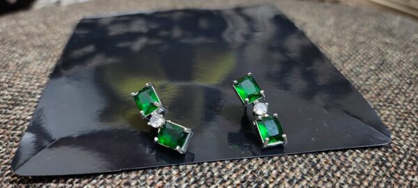 Green emerald stud earrings with cubic zirconia accents.