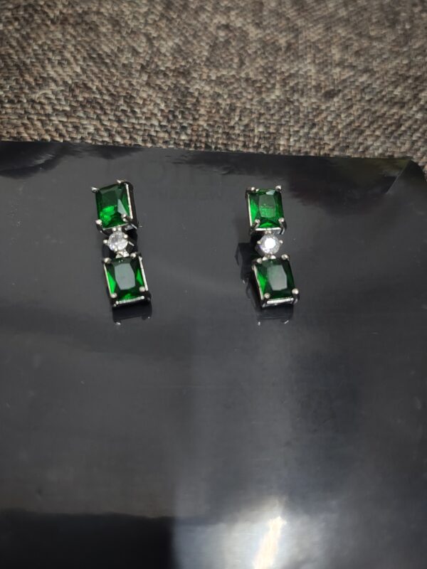 Green emerald stud earrings with cubic zirconia accents.