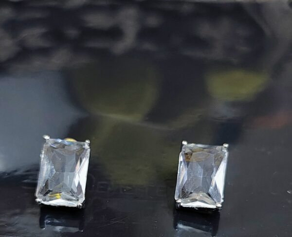 White emerald cut stud earrings with sparkling accents.