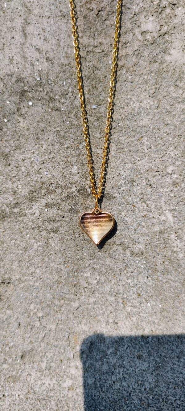 A white heart pendant necklace with a gold-toned chain