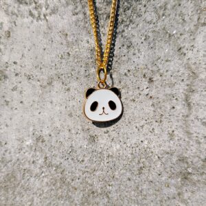 A necklace with a gold-toned chain and a panda pendant.