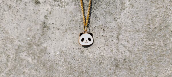 A necklace with a gold-toned chain and a panda pendant.