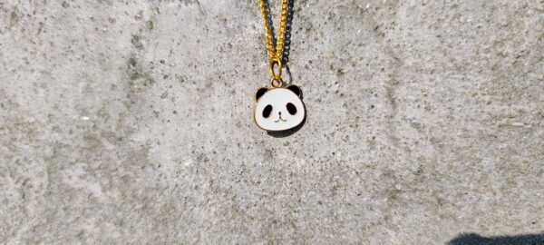 A necklace with a gold-toned chain and a panda pendant.