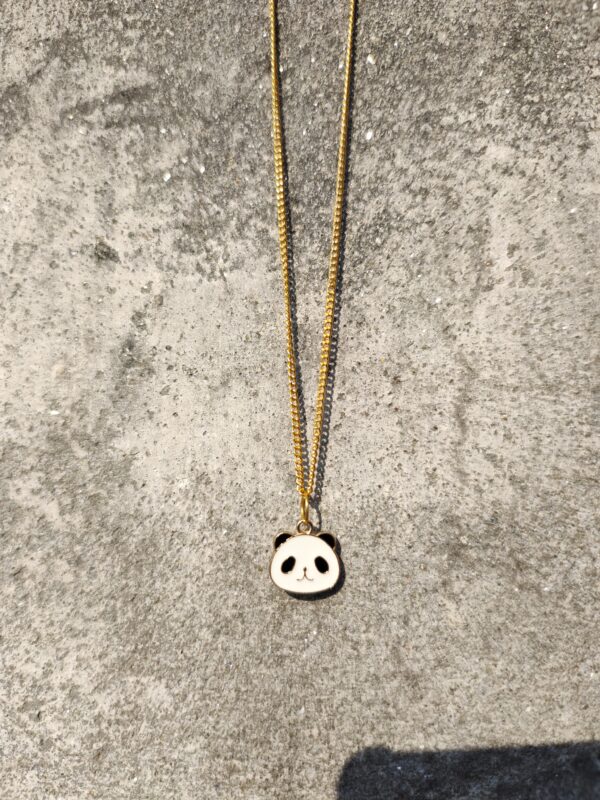 A necklace with a gold-toned chain and a panda pendant.