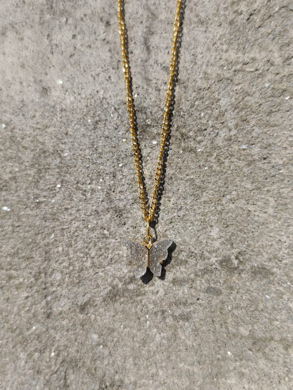 A butterfly necklace with a gold-toned chain and a sparkling butterfly pendant.