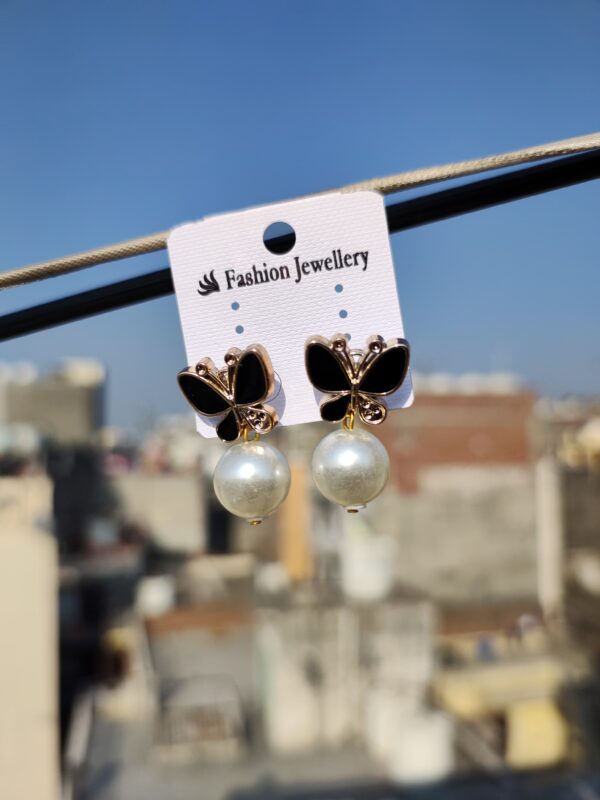 Black butterfly earrings with pearl accents.