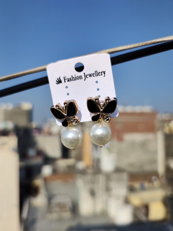 Black butterfly earrings with pearl accents.