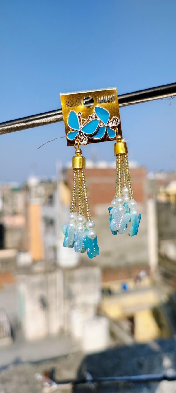 Blue butterfly earrings with tassels and pearl accents.