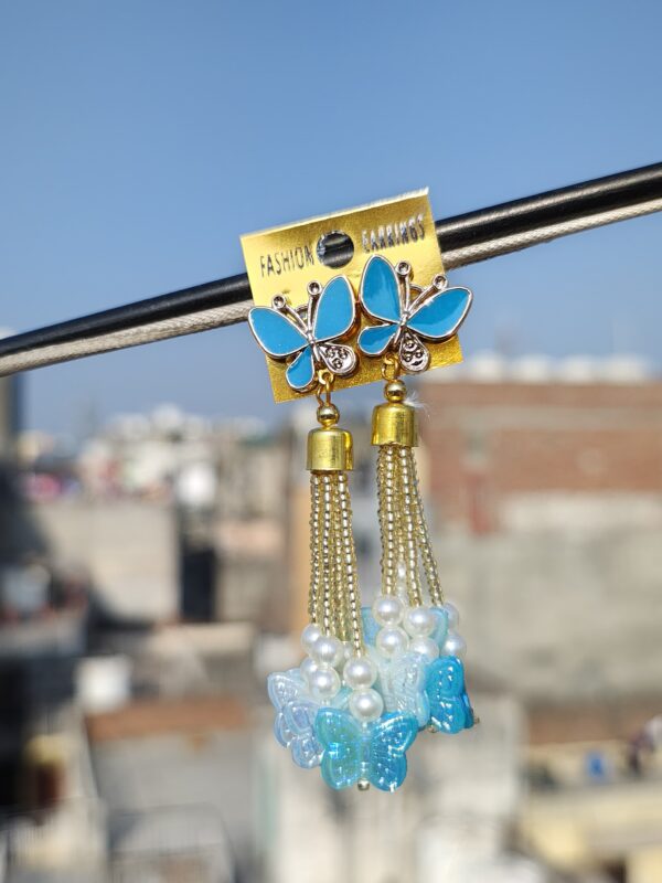 Blue butterfly earrings with tassels and pearl accents.