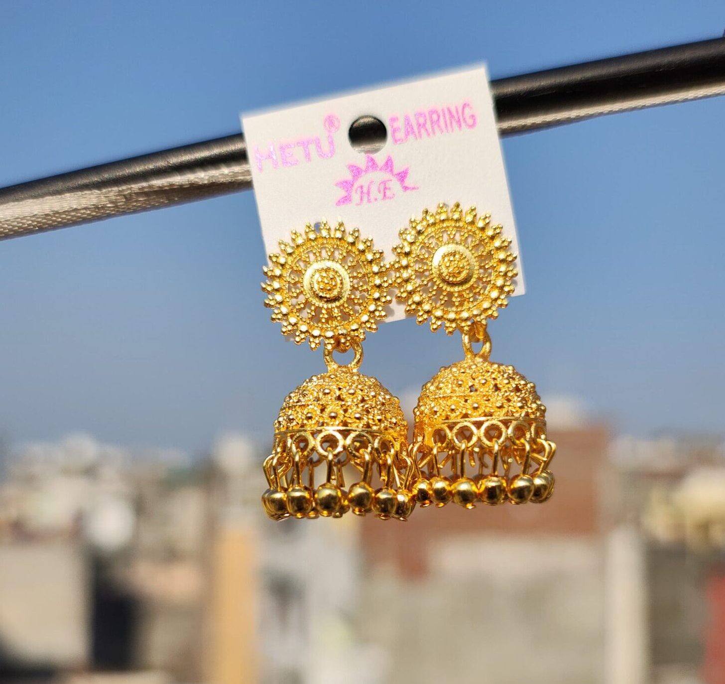 Gold-toned jhumka earrings with intricate designs.