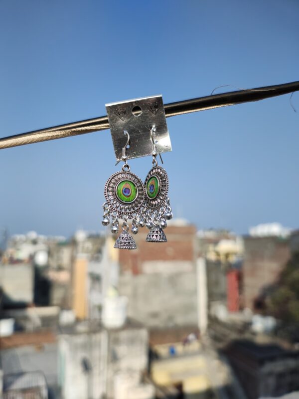 Oxidized silver earrings with a peacock feather design.