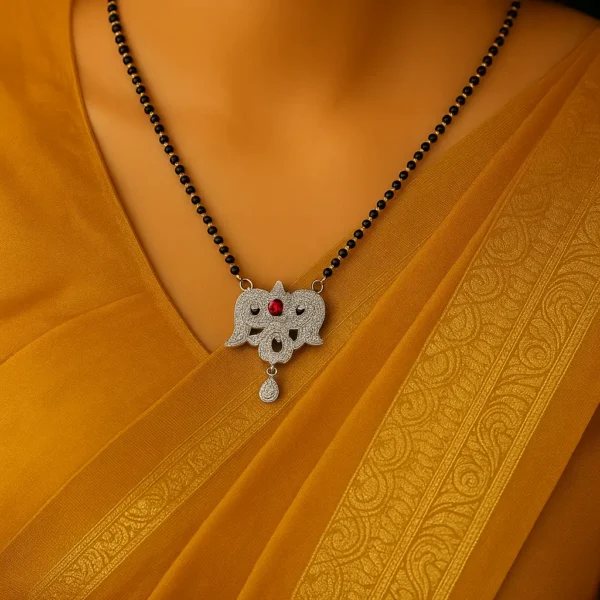 Woman wearing a gold saree and a pink stone mangalsutra with twin elephant design